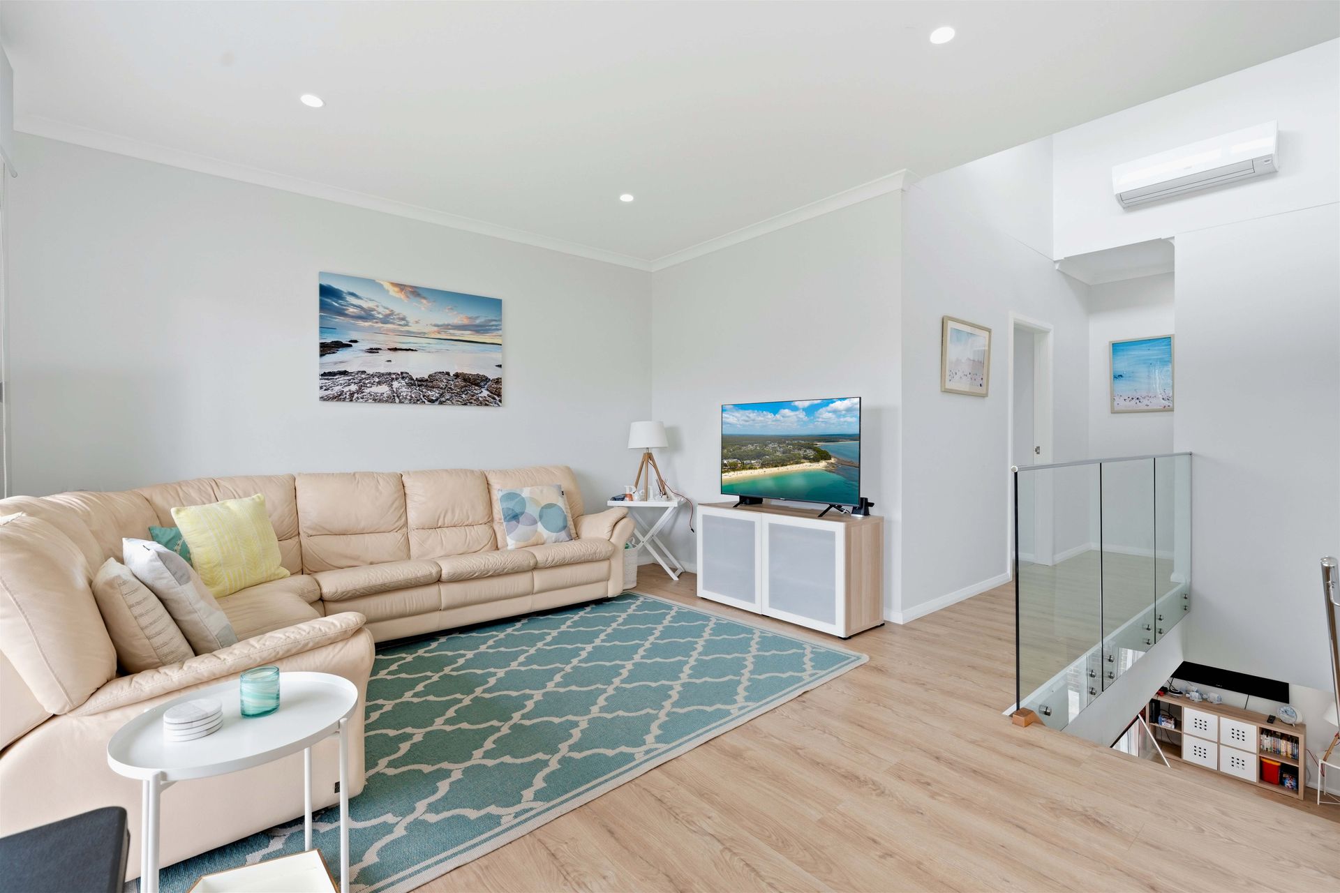 Upstairs living area with a large lounge, rug and Smart TV